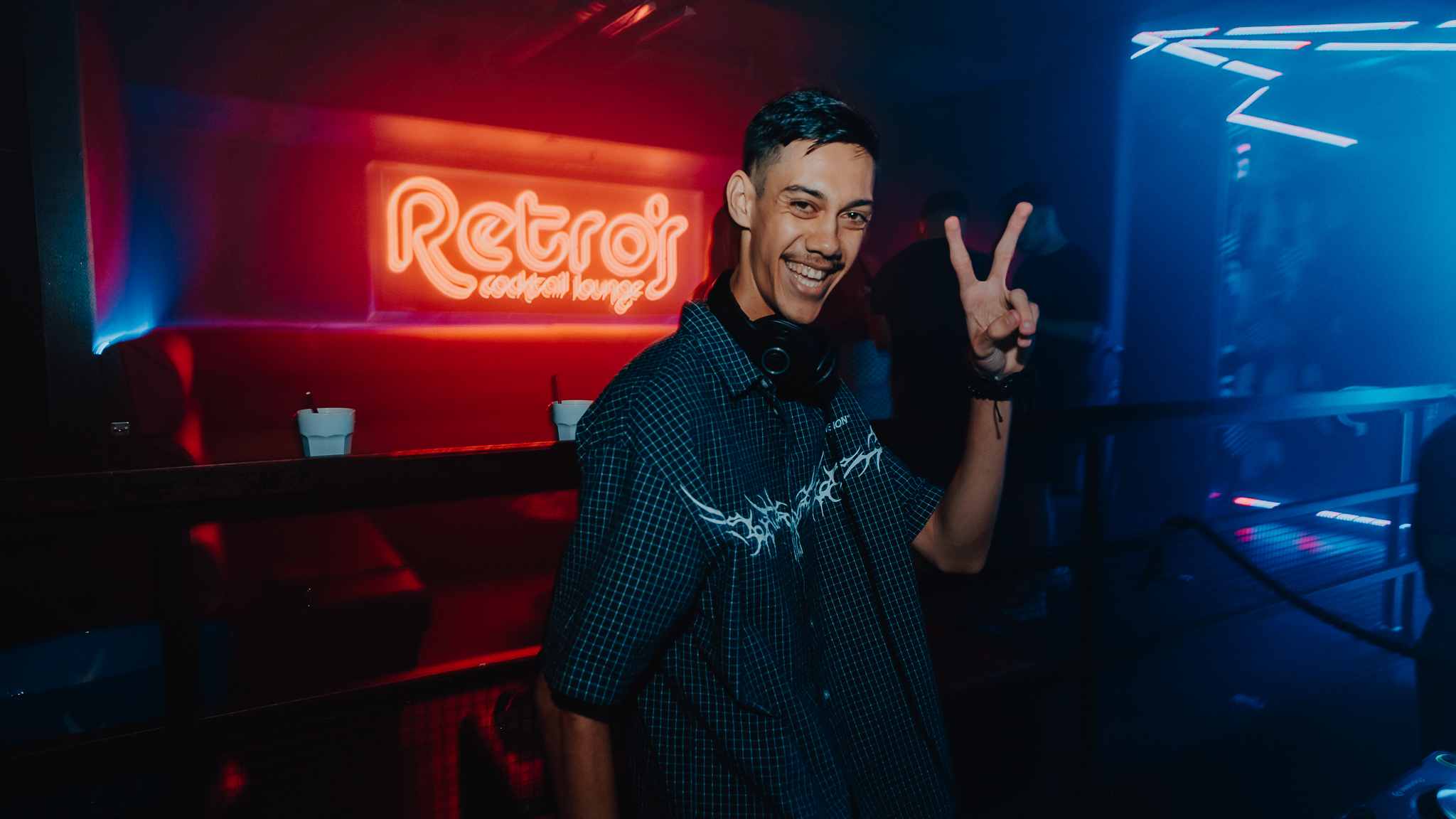 DJ posed at Retros neon sign, Surfers Paradise